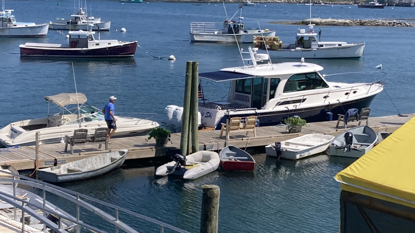 Lobster boats, dinghies, and a powerboat docked at a working waterfront harbor in Maine