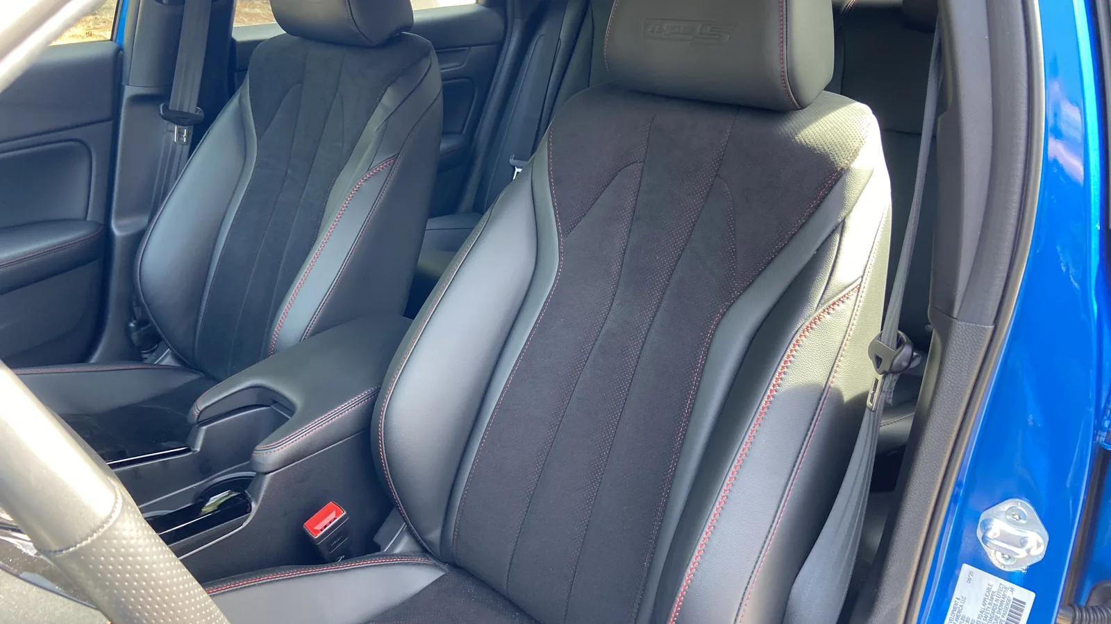 Front Ultrasuede sport seats with red stitching inside the 2026 Acura Integra Type S.