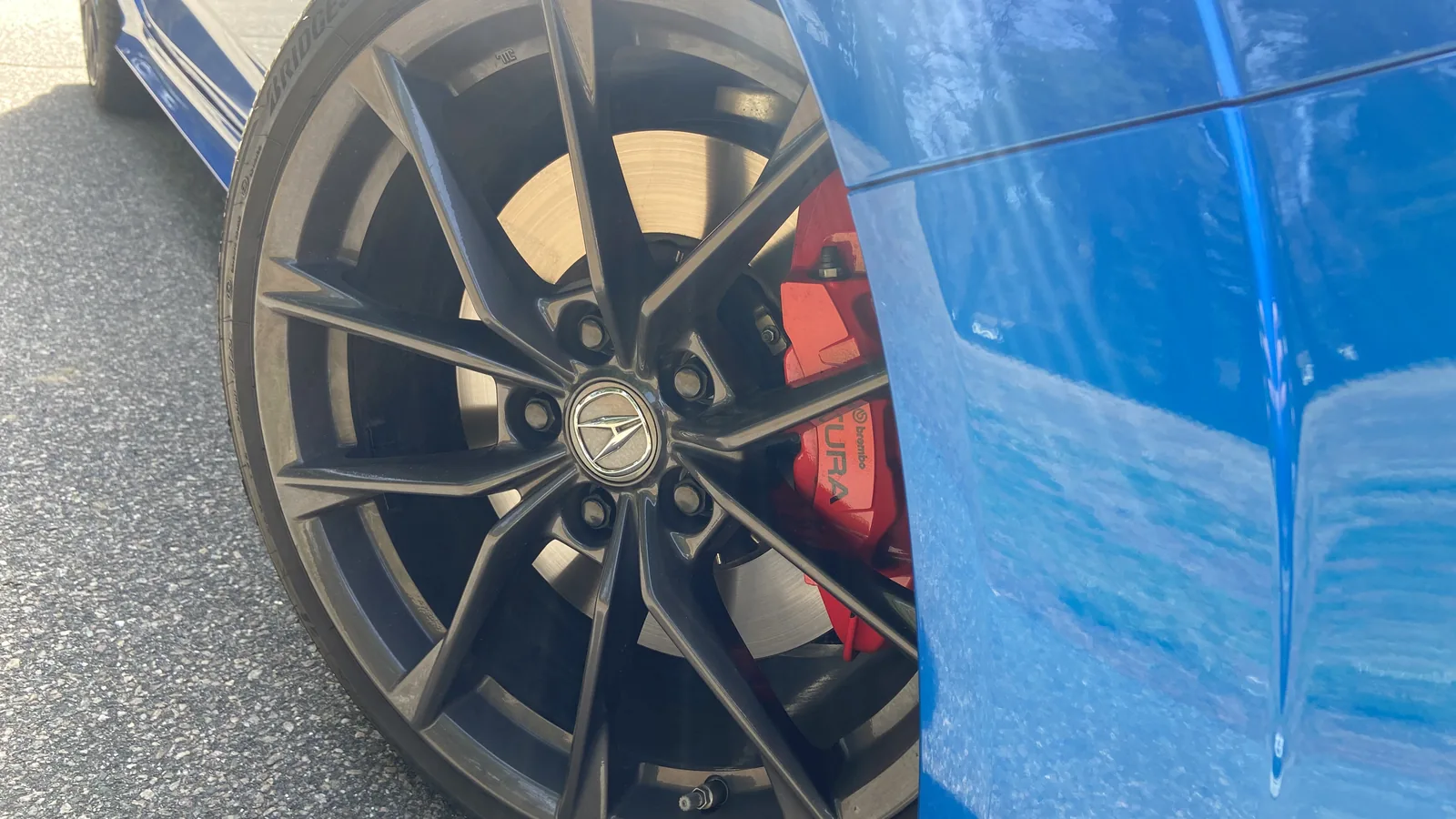 Close-up of a 2026 Acura Integra Type S alloy wheel with a red performance brake caliper.